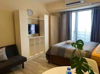 a hotel room with a bed and a tv in it at Amazing 1 bedroom with pool, gym and stunning view at heart of Makati in Manila