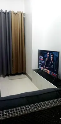 a bedroom with a flat screen tv next to a bed at Natalie's Place in Mall of Asia Complex in Manila