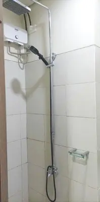 a shower with a shower head in a bathroom at Natalie's Place in Mall of Asia Complex in Manila