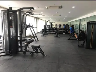 a gym with tread machines and people in the background at Natalie's Place in Mall of Asia Complex in Manila