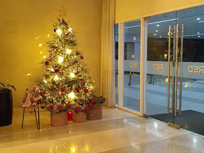 a christmas tree in the lobby of a building at Home of the GoodVibes Red Residences Makati in Manila