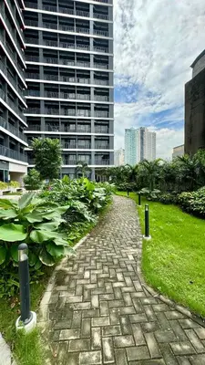 a brick path in front of a tall building at Home of the GoodVibes Red Residences Makati in Manila