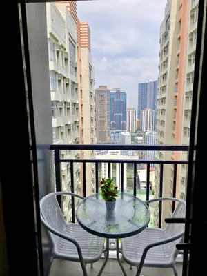 a table and chairs on a balcony with a view at Home of the GoodVibes Red Residences Makati in Manila