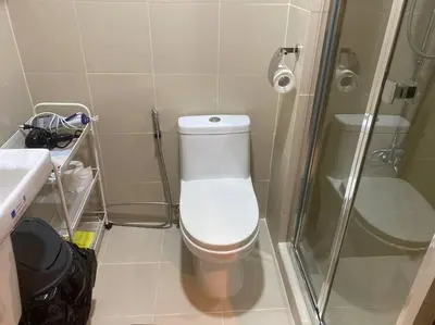 a small bathroom with a toilet and a shower at 1BR CONDO Fame Residences Mandaluyong- Be My Guest Staycation- Near SM Megamall, Greenfield District, & Ortigas in Manila
