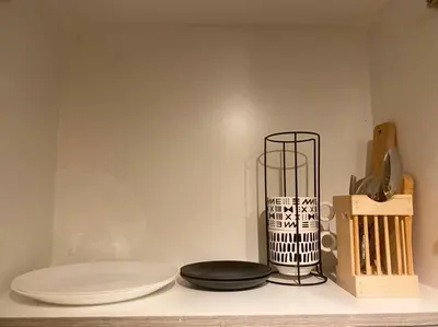 a shelf with plates and a vase on it at 1BR CONDO Fame Residences Mandaluyong- Be My Guest Staycation- Near SM Megamall, Greenfield District, & Ortigas in Manila