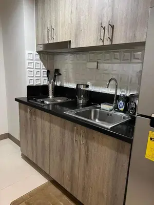 a kitchen with a sink and a refrigerator at Twin Duckworth Suites T1 in Manila