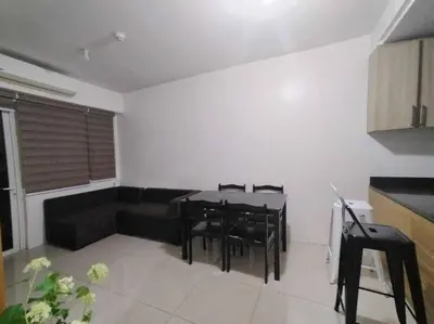 a living room with a couch and a table and chairs at Spacious 2-BR Condo - Shore Residence Tower D - Walking distance to Moa in Manila