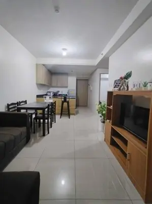 a living room and kitchen with a couch and a television at Spacious 2-BR Condo - Shore Residence Tower D - Walking distance to Moa in Manila