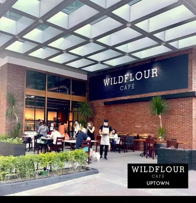 a group of people standing outside of a restaurant at Cozy 1 bedroom condo in Uptown BGC in Manila