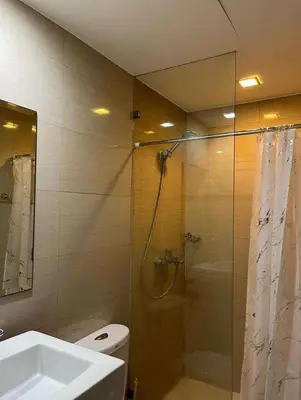 a bathroom with a shower and a toilet and a sink at The Viceroy Tower1 condominium in Manila