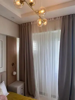 a bedroom with a bed and a window with curtains at Haiya's Staycation Aesthetic & Cozy in Tagaytay in Biluso
