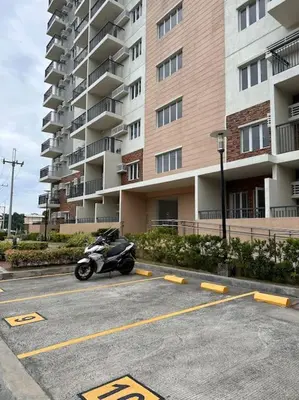 a motorcycle parked in a parking lot in front of a building at Haiya's Staycation Aesthetic & Cozy in Tagaytay in Biluso