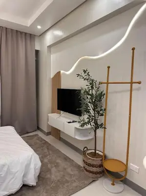 a bedroom with a bed and a tv and a plant at Haiya's Staycation Aesthetic & Cozy in Tagaytay in Biluso