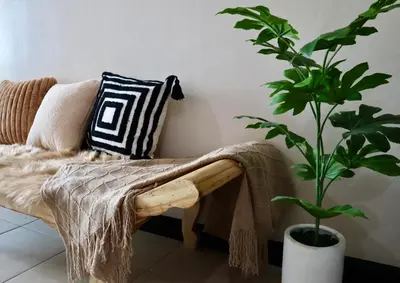 a living room with a couch and a plant at Luxury Bauhaus inspired apartment near Makati in Manila