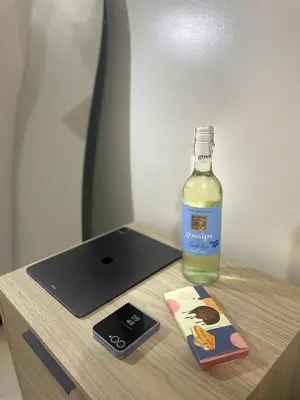 a bottle of alcohol sitting on a table next to a tablet at Luxury Bauhaus inspired apartment near Makati in Manila