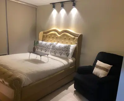 a bedroom with a bed with a table and a chair at Luxurious 2 BR at Eastwood City in Manila