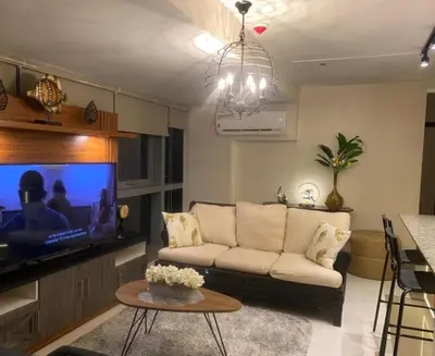 a living room with a couch and a tv at Luxurious 2 BR at Eastwood City in Manila