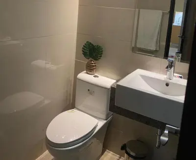 a bathroom with a white toilet and a sink at Luxurious 2 BR at Eastwood City in Manila