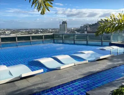 a swimming pool with lounge chairs on top of a building at Luxurious 2 BR at Eastwood City in Manila