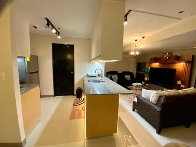 a kitchen and living room with a couch and a table at Luxurious 2 BR at Eastwood City in Manila