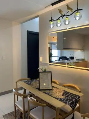 a laptop sitting on a wooden table in a kitchen at Luxurious 2 BR at Eastwood City in Manila
