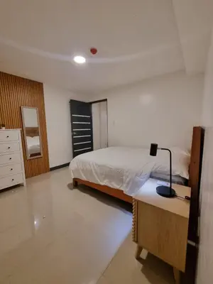 a bedroom with a bed and a lamp on a desk at Flat 35, Unit 2A in Manila