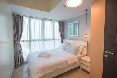 a bedroom with a bed with a large window at Luxury 120sqm suite Uptown BGC with spectacular balcony view in Manila
