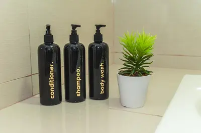 three black bottles sitting next to a potted plant at Luxury 120sqm suite Uptown BGC with spectacular balcony view in Manila