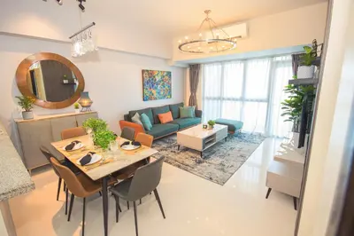 a living room with a table and a couch at Luxury 120sqm suite Uptown BGC with spectacular balcony view in Manila
