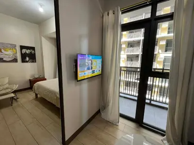 a room with a bed and a window with a view at GENTRY MANOR fast WiFi,Balcony near Okada,MOA&NAIA 8Q in Manila
