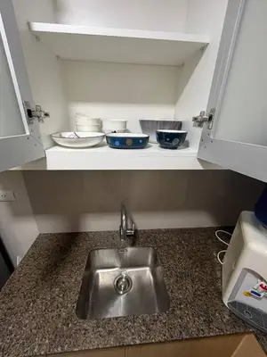 a kitchen counter with a sink and bowls on a shelf at GENTRY MANOR fast WiFi,Balcony near Okada,MOA&NAIA 8Q in Manila