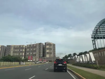 a car driving down a highway with tall buildings at GENTRY MANOR fast WiFi,Balcony near Okada,MOA&NAIA 8Q in Manila