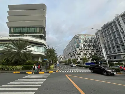 a street in a city with buildings and a car at GENTRY MANOR fast WiFi,Balcony near Okada,MOA&NAIA 8Q in Manila