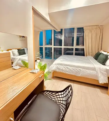a bedroom with a bed and a desk with a chair at 1BR Luxury unit in Uptown Parksuites -Walking distance to Malls in Manila