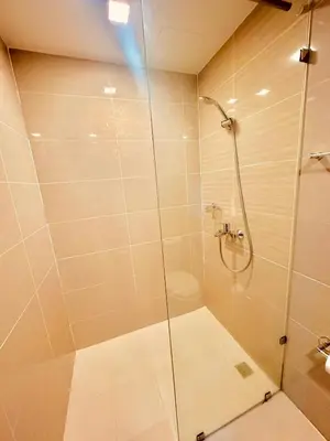a shower with a glass door in a bathroom at 1BR Luxury unit in Uptown Parksuites -Walking distance to Malls in Manila