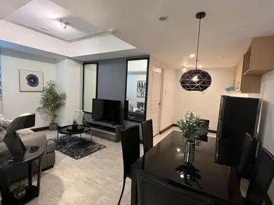 a living room with a table and a dining room at Stylish 1BR At Avant BGC in Manila