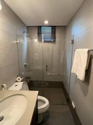 a bathroom with a shower and a toilet and a sink at Stylish 1BR At Avant BGC in Manila