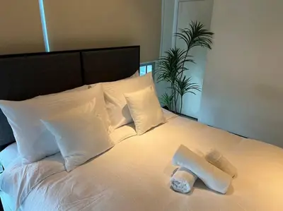 a white bed with a pair of towels on it at Stylish 1BR At Avant BGC in Manila