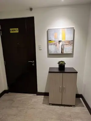 a room with a door and a cabinet with a plant at Stylish 1BR At Avant BGC in Manila