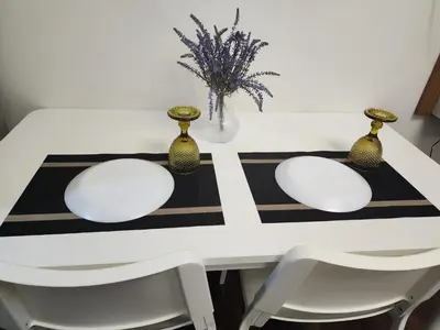 a white dining room table with gold vases on it at Julie's Place in Manila