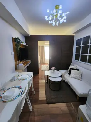 a living room with two tables and a couch at Julie's Place in Manila