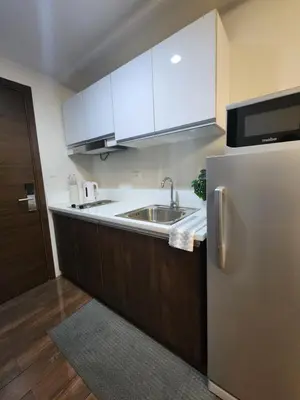 a kitchen with a sink and a stainless steel refrigerator at Julie's Place in Manila