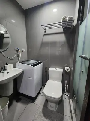 a bathroom with a white toilet and a sink at Julie's Place in Manila