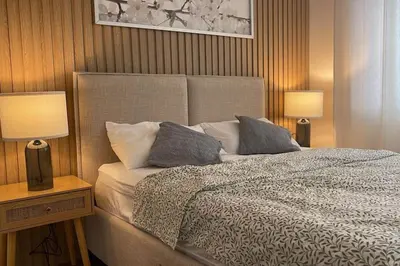 a bedroom with a large bed with two lamps at Luxa House Staycation Tagaytay in Panungyanan
