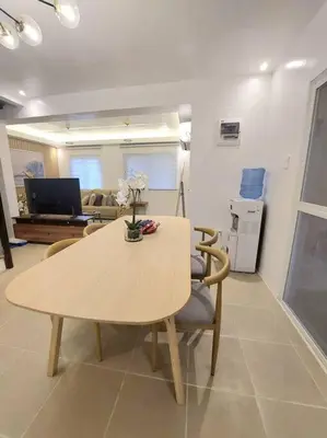 a dining table and chairs in a living room at Luxa House Staycation Tagaytay in Panungyanan
