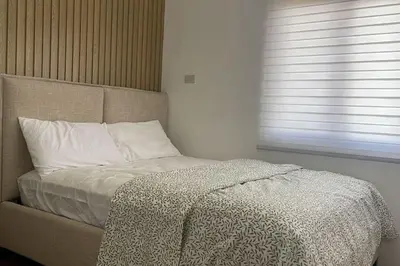 a bed in a room with a window and a bedskirtspectspectspectspects at Luxa House Staycation Tagaytay in Panungyanan