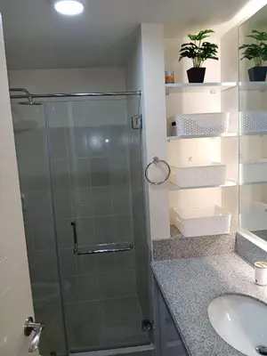 a bathroom with a glass shower and a sink at Smith's Place in Manila
