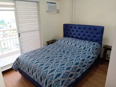 a bedroom with a bed with a blue comforter at Smith's Place in Manila