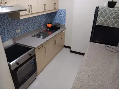 a small kitchen with a sink and a stove at Smith's Place in Manila