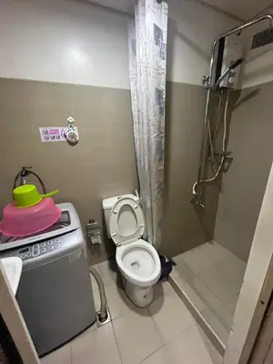 a small bathroom with a toilet and a shower at Budget SHORE Family Suite 2 Bed WiFi Netflix MOA844 in Manila